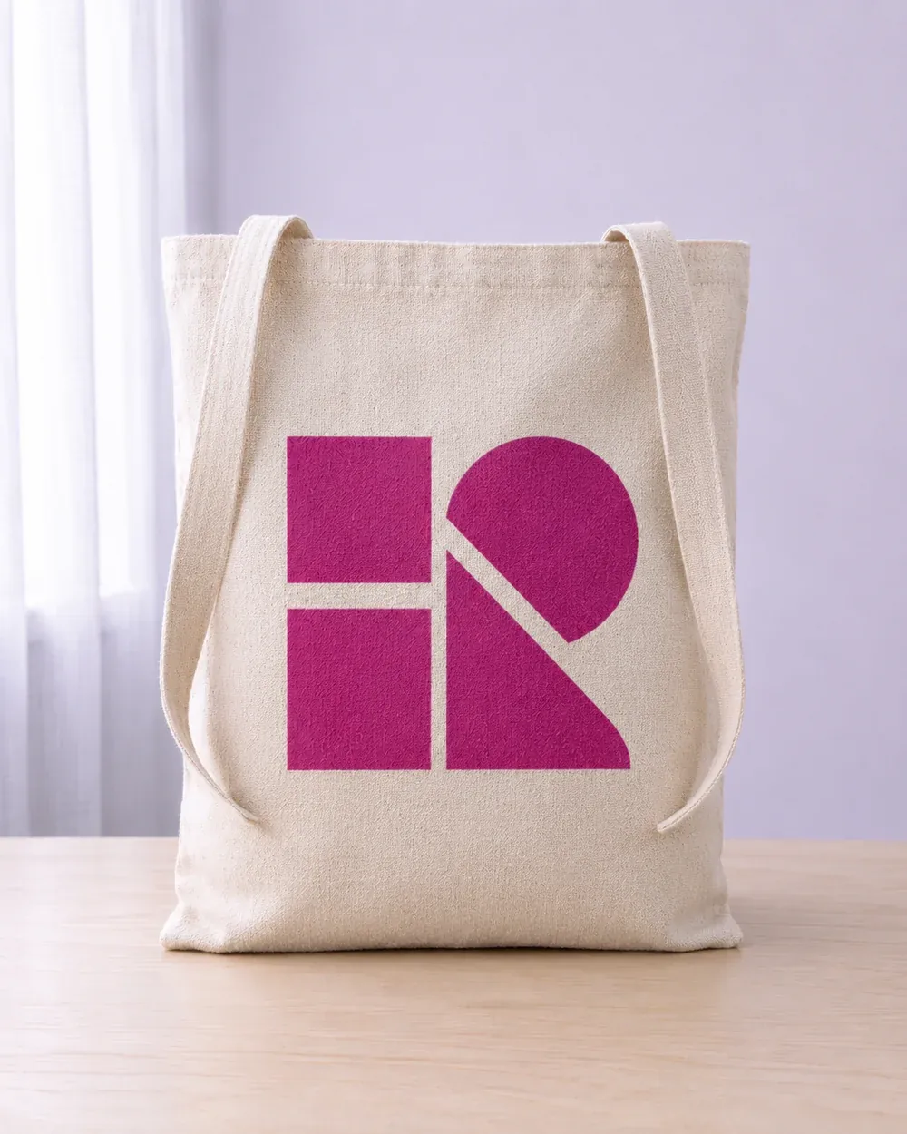 Tote bag de tela cruda de pie sobre una mesa, con estampado geométrico